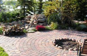 Elegant outdoor living space created using brick patio pavers and landscap block, designed and installed by Exterior Designs of Alexandria