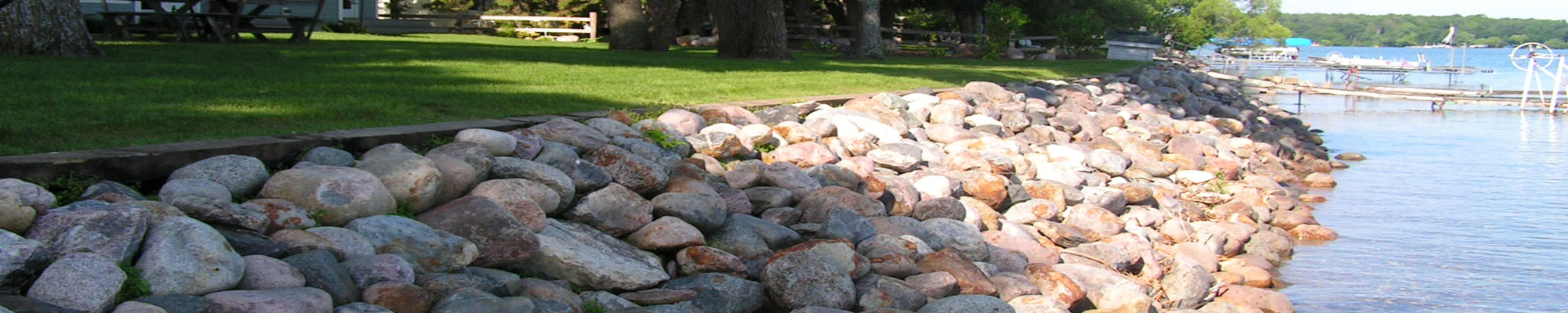 Lakeshore rip-rap of large boulders installed by Exterior Designs of Alexandria for erosion control purposes